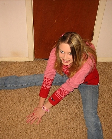 Kitty in jeans sitting on her apartment floor