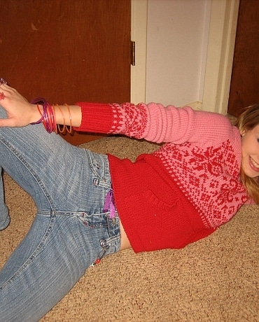 Kitty in jeans sitting on her apartment floor