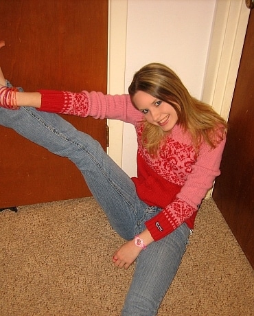 Kitty in jeans sitting on her apartment floor